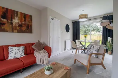 a living room with a red couch and a table at Gray House-Modern 2BR close to Loch Lomond in Alexandria