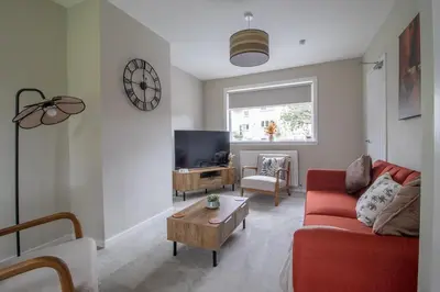 a living room with a red couch and a tv at Gray House-Modern 2BR close to Loch Lomond in Alexandria
