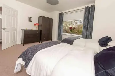 a bedroom with two white beds and a window at Dalziel House-3 bedroom Hamilton in Hamilton