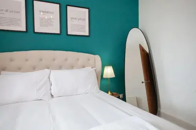 a bedroom with a white bed and a green wall at 1 Bed Cosy Loch Lomond base in Bonhill