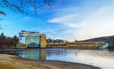 a building next to a body of water at 1 Bed Cosy Loch Lomond base in Bonhill
