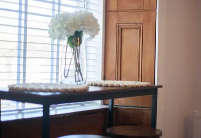 a table with a vase of flowers in a room at 1 Bed Cosy Loch Lomond base in Bonhill