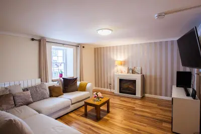 a living room with a couch and a fireplace at Lochfyne-View Apartment in Inveraray