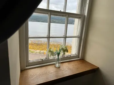 a vase of flowers sitting on a window sill at Lochfyne-View Apartment in Inveraray