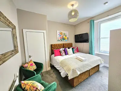 a bedroom with a bed with pink pillows and a window at Sensational Stay- Fountainbridge in Edinburgh