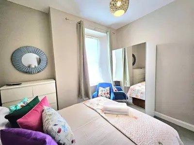 a bedroom with a bed and a mirror at Sensational Stay- Fountainbridge in Edinburgh