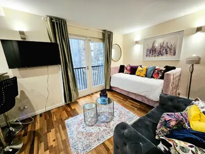 a living room with a couch and a flat screen tv at 2 bedroom, 4 beds -Grassmarket in Edinburgh