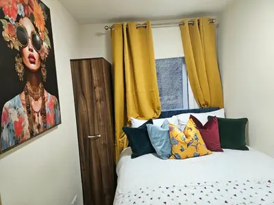 a bedroom with a bed and a painting of a woman at 2 bedroom, 4 beds -Grassmarket in Edinburgh