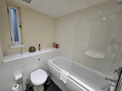 a bathroom with a tub and a toilet and a sink at 2 bedroom, 4 beds -Grassmarket in Edinburgh