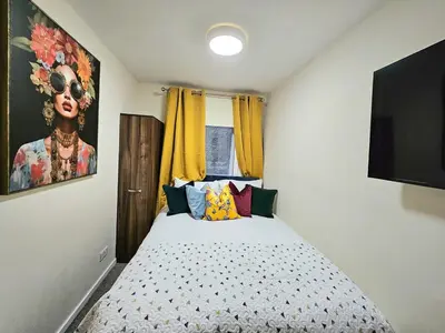 a bedroom with a bed and a painting of a woman at 2 bedroom, 4 beds -Grassmarket in Edinburgh
