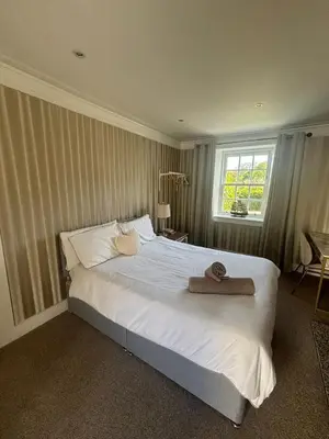 a bedroom with a white bed with a towel on it at Brig o Doon 3 in Ayr
