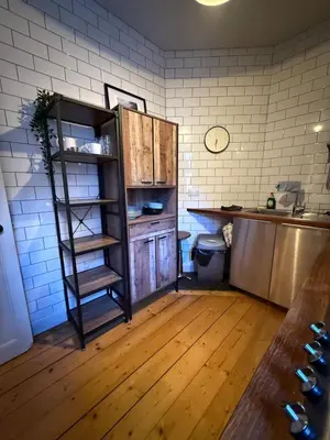a kitchen with a shelf in the corner of a room at Dean Village, Edinburgh in Edinburgh