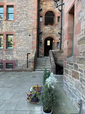 a stone building with two potted plants and stairs at Dean Village, Edinburgh in Edinburgh