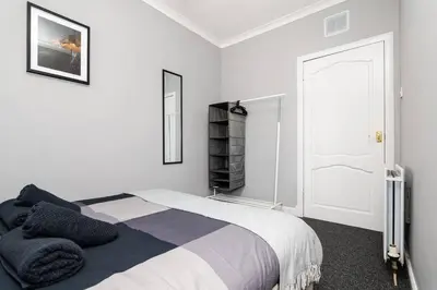 a white bedroom with a bed and a white door at Ideal Work Stays 3BR Free Parking Sleeps 6 in Falkirk