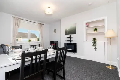 a dining room and living room with a table and chairs at Ideal Work Stays 3BR Free Parking Sleeps 6 in Falkirk