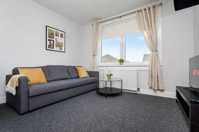 a living room with a couch and a window at Ideal Work Stays 3BR Free Parking Sleeps 6 in Falkirk