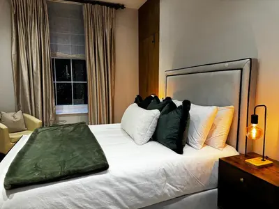 a bedroom with a large white bed with pillows at The Victorian Residence in Moffat