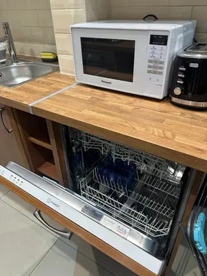 a microwave oven sitting on top of a kitchen counter at City Centre Ground floor 3 Bedroom Apartment in Edinburgh