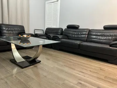 a living room with a black couch and a glass table at City Centre Ground floor 3 Bedroom Apartment in Edinburgh