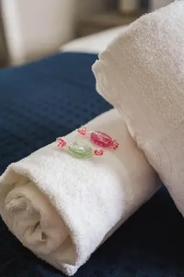 a towel with flowers on it sitting on a bed at Coat Apartment in Coatbridge