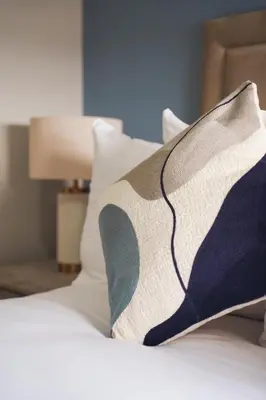 a close up of a bed with pillows on it at Coat Apartment in Coatbridge