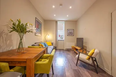 a living room with a table and a couch at Stylish 2Bedroom Flat - Central Oban in Oban