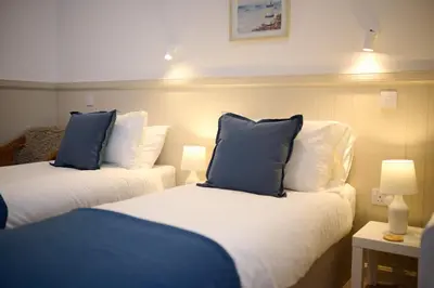 a room with two beds with blue and white pillows at Luxury 3BD Central Apt with Tower & Seaviews in Oban