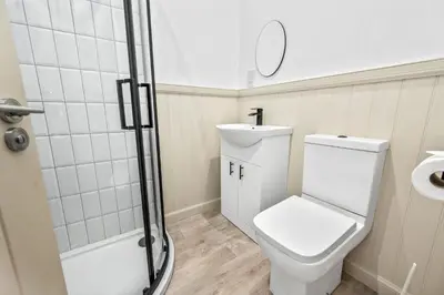 a white bathroom with a toilet and a shower at Luxury 3BD Central Apt with Tower & Seaviews in Oban