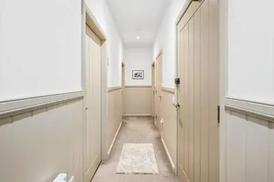 a hallway with doors and a rug on the floor at Luxury 3BD Central Apt with Tower & Seaviews in Oban