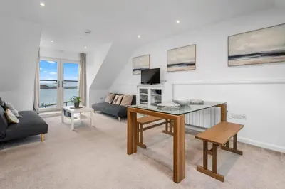 a living room with a table and a couch at Breathtaking Sea Views - Luxury 2 BD Apt in Oban