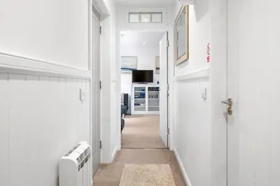 a hallway with white walls and a white door at Breathtaking Sea Views - Luxury 2 BD Apt in Oban