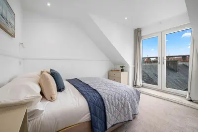 a bedroom with a bed and a large window at Breathtaking Sea Views - Luxury 2 BD Apt in Oban