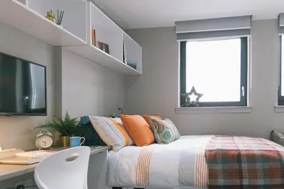 a bedroom with a bed and a desk with a computer at For Students Only - George Street in Glasgow in Glasgow