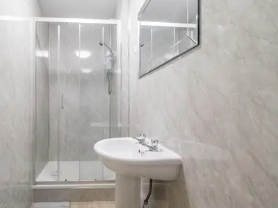 a white bathroom with a sink and a shower at Pass the Keys Cosy in Fabulous West End in Glasgow
