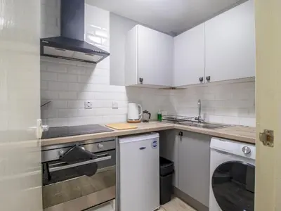 a kitchen with white cabinets and a dishwasher at Pass the Keys Cosy in Fabulous West End in Glasgow