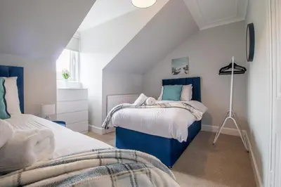 a bedroom with two beds in a attic at Cairnhill House - cosy 3 bedroom in Airdrie