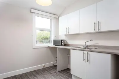 a kitchen with white cabinets and a window at The Bay Suite - Donnini Apartments in Troon
