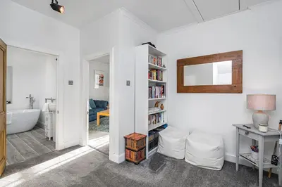 a living room with a book shelf and a bath tub at The Old Jail - Iconic Views in North Queensferry