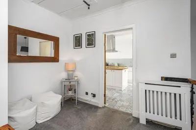 a living room with a white couch and a mirror at The Old Jail - Iconic Views in North Queensferry