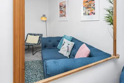 a mirror reflecting a blue couch in a living room at The Old Jail - Iconic Views in North Queensferry