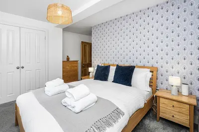 a bedroom with a large white bed with blue walls at The Old Jail - Iconic Views in North Queensferry