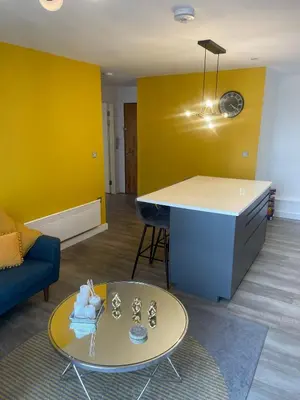 a living room with a table and a yellow wall at The Bank Tower in Moffat