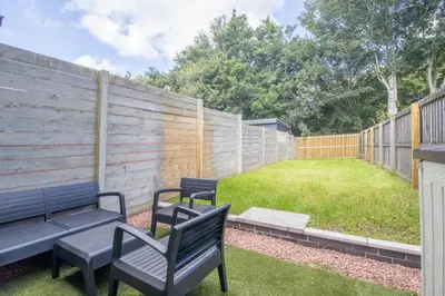 a backyard with two benches and a fence at Modern 2-Bedroom Home near Glasgow & Edinburgh in Airdrie