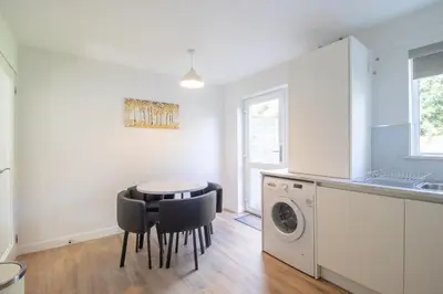 a kitchen with a table and a washing machine at Modern 2-Bedroom Home near Glasgow & Edinburgh in Airdrie