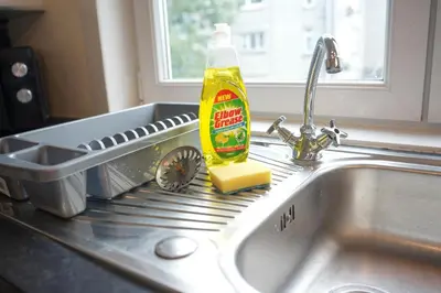 a bottle of detergent and a sponge on a sink at 2 BDR Apt At Caledonia Luxe Stays Short Lets & Serviced Accommodation Airdrie in Airdrie