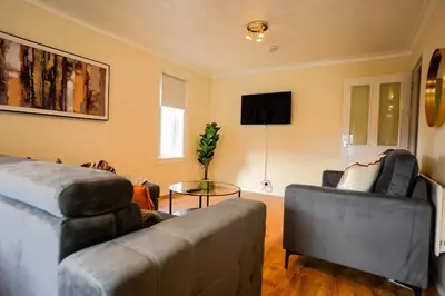 a living room with a couch and a chair at 2 BDR Apt At Caledonia Luxe Stays Short Lets & Serviced Accommodation Airdrie in Airdrie