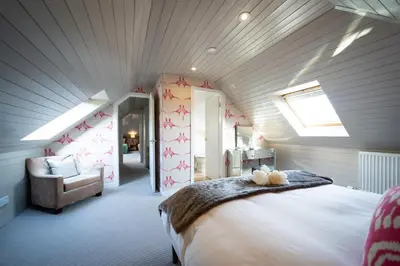 a bedroom with a large bed in a attic at Buzzard Cottage nestled in a hillside farm in Stirling