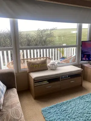 a living room with a large window and a tv at Turnberry holiday park in Turnberry