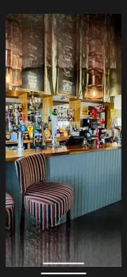 a bar with two stools in front of a counter at Turnberry holiday park in Turnberry