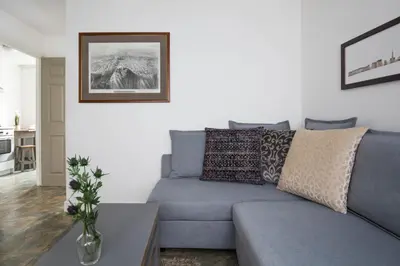 a living room with a blue couch and a table at Grassmarket Apartment in Edinburgh